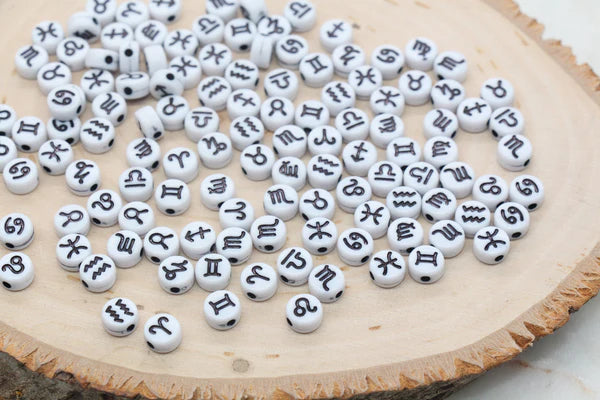 White plastic beads with different zodiac sign on each of them