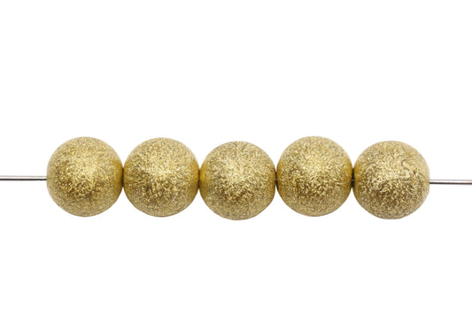 Five gold beads on a white background