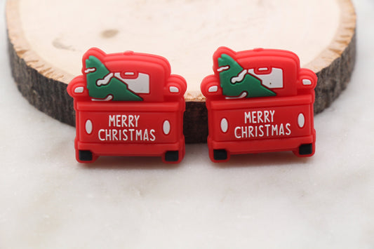 Two red Christmas-themed cable protectors on a wooden surface.