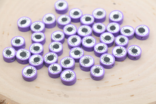 Purple tokens with eye and spider designs on a wooden surface.