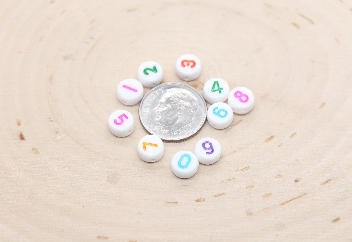 individual 7 mm round acrylic number beads, multicolor on white; multicolor number beads