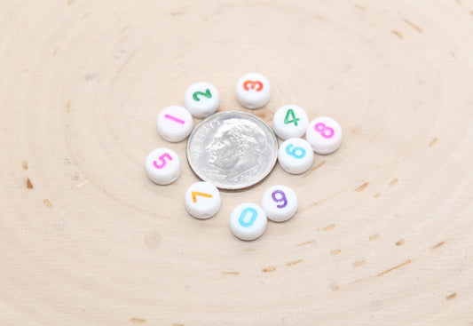 individual 7 mm round acrylic number beads, multicolor on white; multicolor number beads