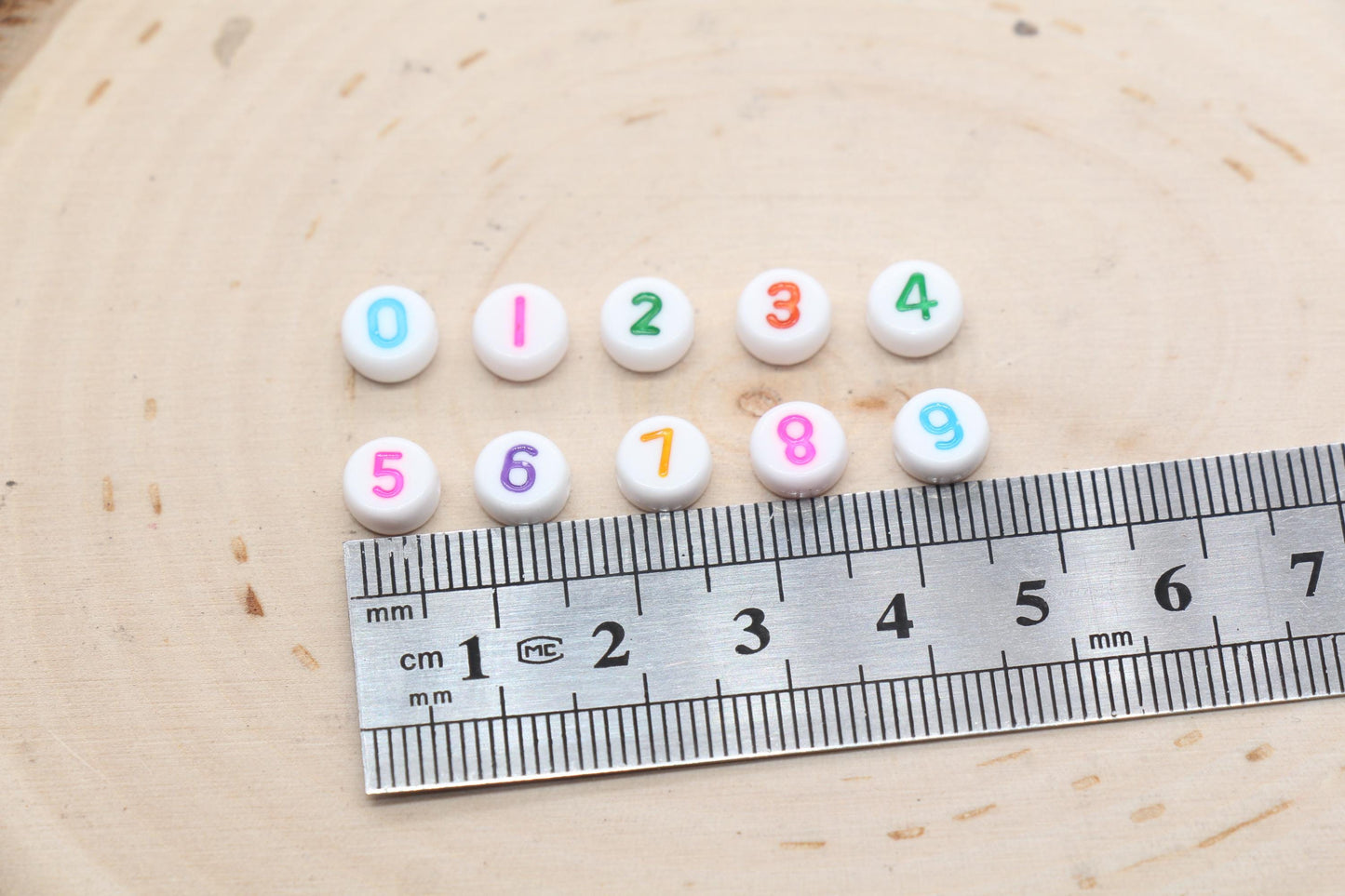 individual 7 mm round acrylic number beads, multicolor on white; multicolor number beads