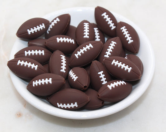 A bowl of chocolate candies shaped like American footballs.