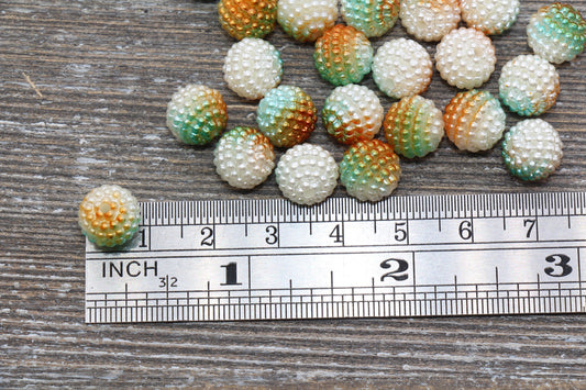 Beads scattered next to a ruler on a wooden surface for size comparison.