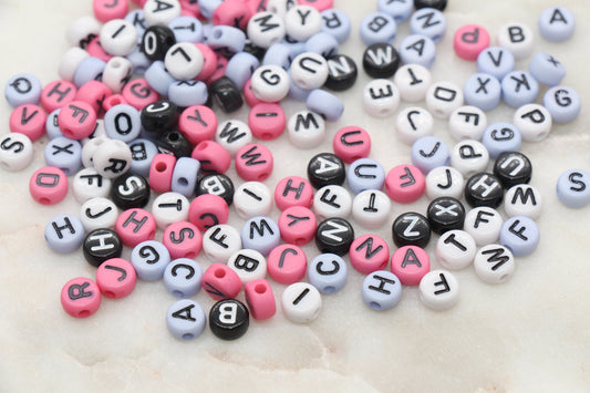 Colorful alphabet beads scattered on a light surface.