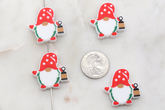 Four gnome-shaped earrings displayed next to a quarter for scale.