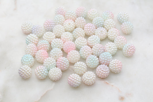 Assorted pastel-colored sugar pearls on a light surface.