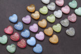 A collection of multicolored heart-shaped glitter beads