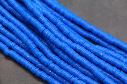 Close-up of blue heishi beads on a gray background