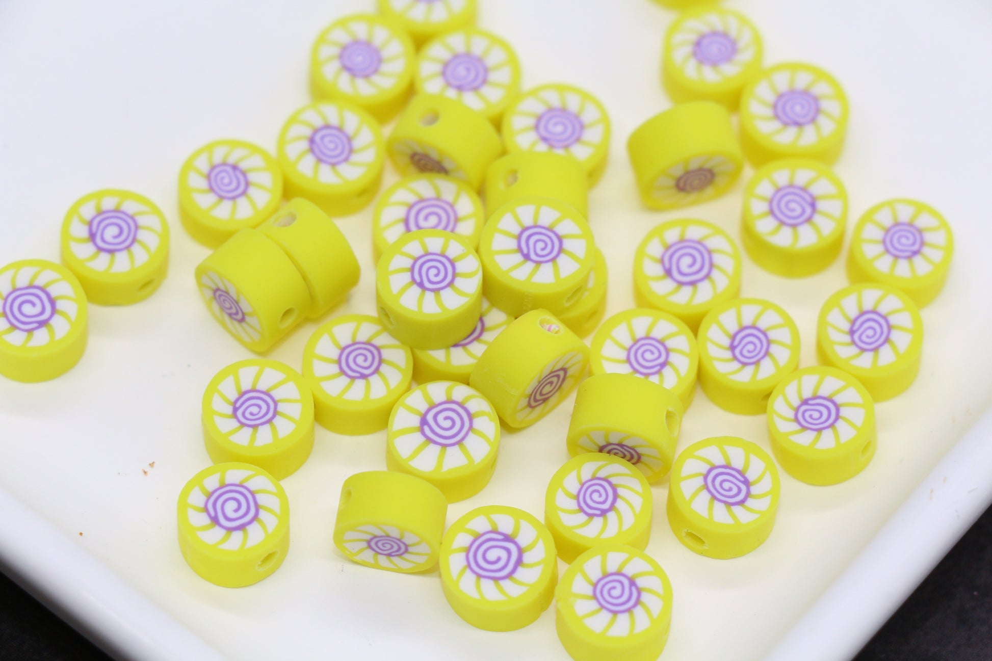 Yellow and purple decorative beads on a white surface