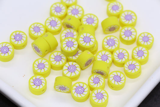 Yellow and purple decorative beads on a white surface