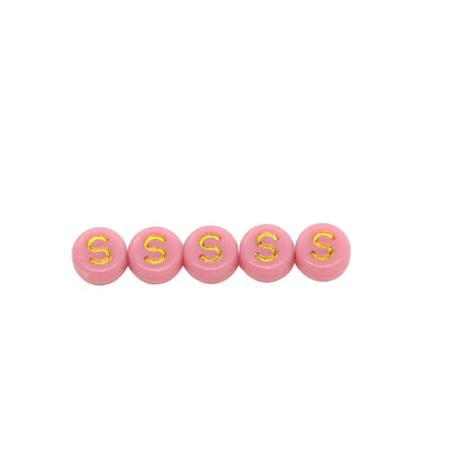 Five pink beads with gold letters 'S' on a white background