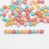 Pastel-colored beads with numbers on a white background