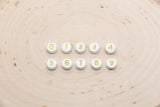 individual 7 mm round acrylic number beads, gold on white; gold number beads