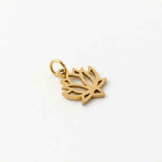 Angled gold-plated stainless steel openwork lotus pendant with attached jump ring on neutral ivory background