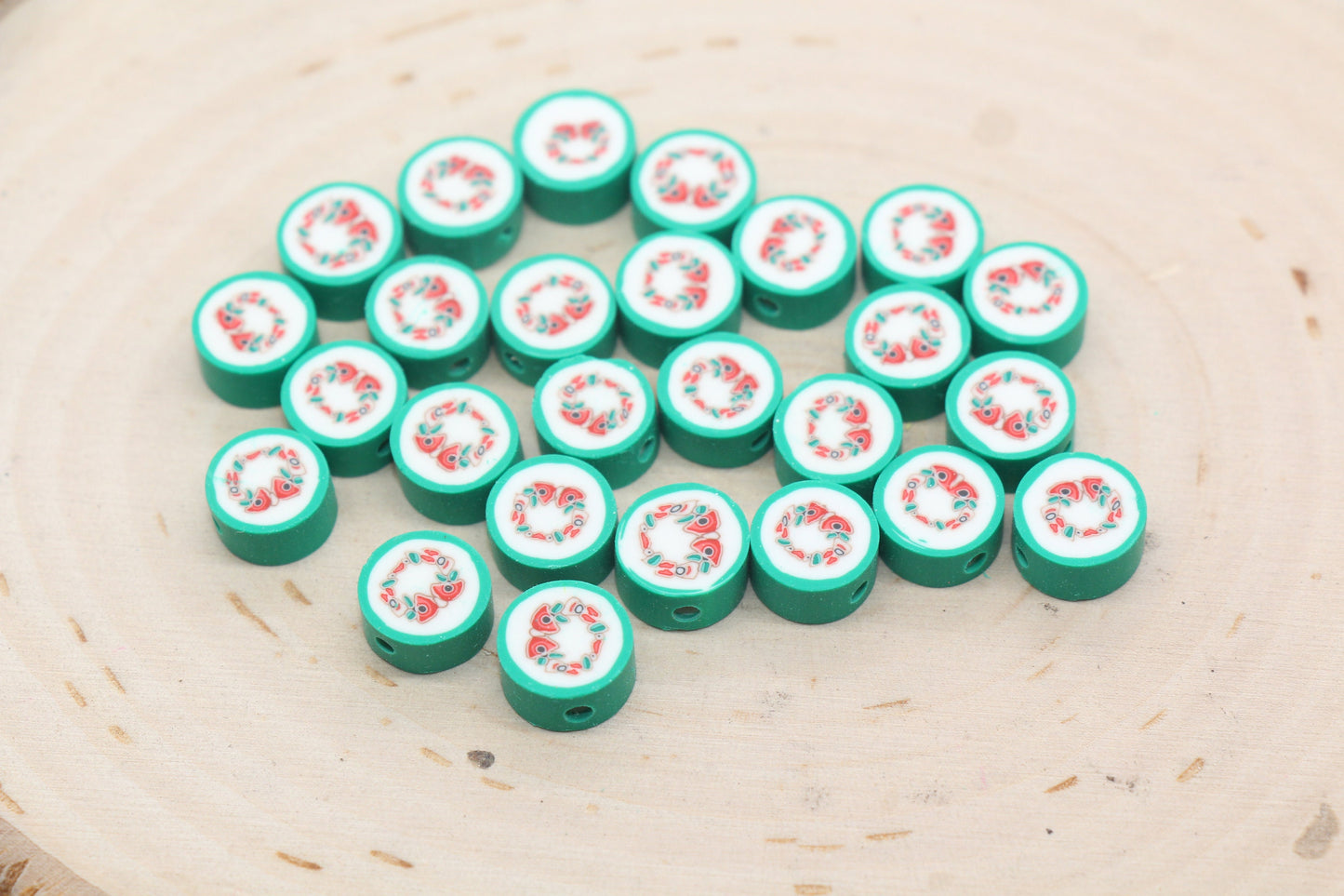 A collection of green game pieces with a red and white design on a wooden surface.