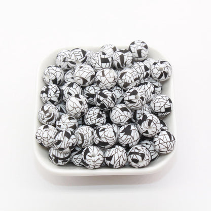 A bowl filled with black and white patterned round beads.