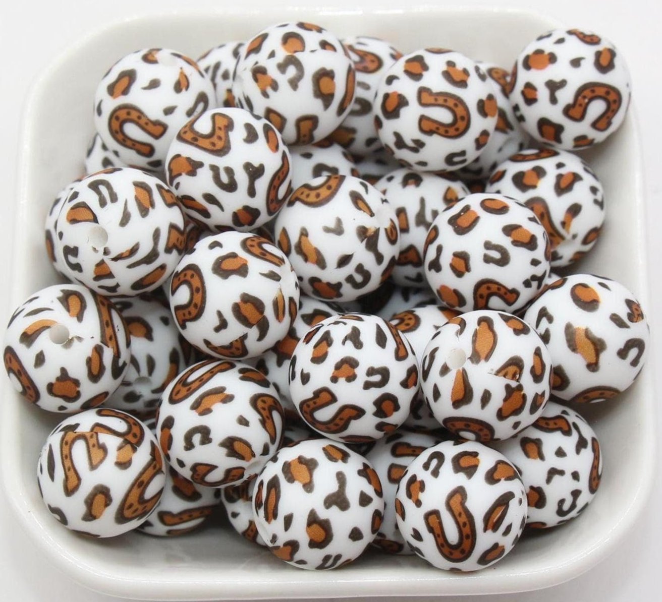 round beads in a white square bowl with white blank background