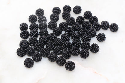 A pile of fresh blackberries on a white surface.